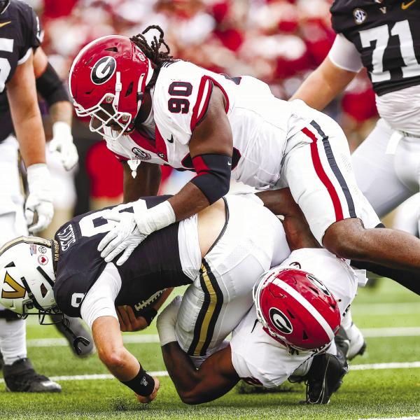 Georgia defensive lineman Tramel Walthour (90) and inside linebacker Smael Mondon Jr. (2) tackle Vanderbilt quarterback Ken Seals (8) during Saturday’s TONY WALSH/UGA Athletics game in Nashville.