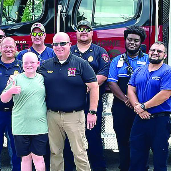 Justin Gilstrap poses with a group of Morgan County first responders Aug. 3, who helped escort him to Monticello in Jasper County to realize his dream of racing a go-cart. CONTRIBUTED