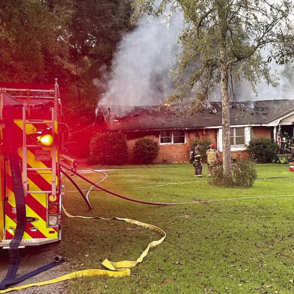 Smoke and flames can be seen on the back of the house as City of Eatonton and Putnam County firefighters begin to battle the blaze. CHIEF WILLIAMSON/Contributed