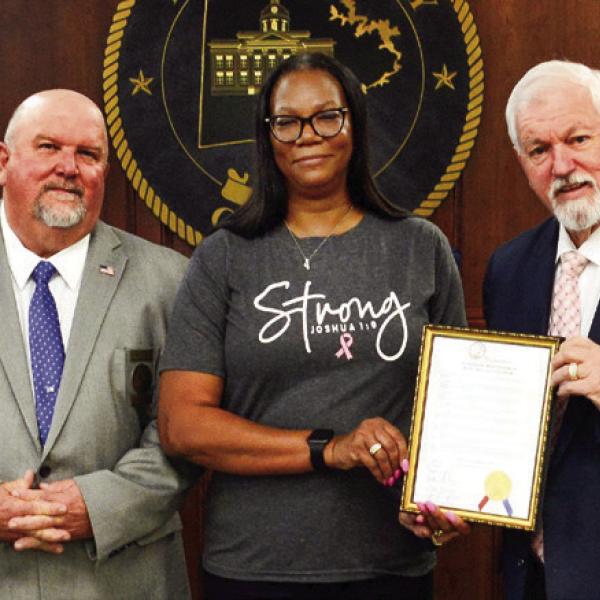 Prior to the start of the Oct. 4 Putnam County Commission meeting, Commission Chairman Bill Sharp (holding frame) invited County Human Resources Director Cynthia Miller to join him and (l-r) Commissioners Daniel Brown, Jeff Wooten, and Stephen Hersey in a proclamation recognizing the month of October as Breast Cancer Awareness Month. (IAN TOCHER/Staff)