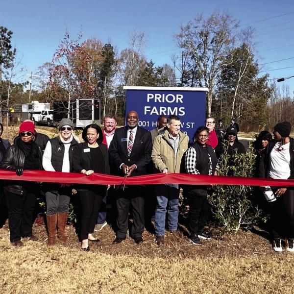 Madison Mayor Fred Perriman (middle) cuts the ribbon, alongside representatives of Woda Cooper Companies Inc. and residents, to celebrate the opening of Prior Farms in Madison. CONTRIBUTED