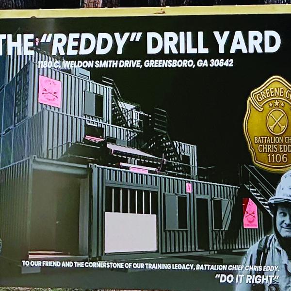Greene County Fire and Rescue B Shift unveils the sign announcing the planned The Reddy Drill Yard named for Chris Eddy, which will be used for training once completed. HEATHER HARRIS/Staff