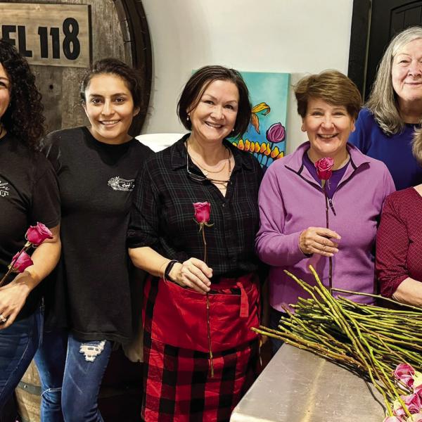 Volunteers from The Artisans Village helped prep hundreds of roses alongside Myrna Taylor (second from left) from Taylor Event and Floral Design. EMMA CLAUSE/Staff