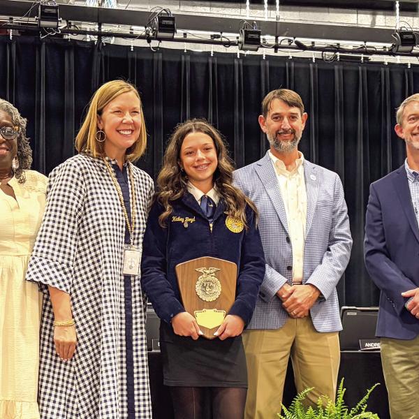 L-R: Morgan County Board of Education members Joe Slaughter, Cheryl Bland, Dr. Susan Stancil, Brad Hawk, Dr. Forest Pagett, and Andrew Ainslie III recognized MCMS eighth grader Hailey Boyd, who was named recently FFA state winner for Middle School Horticulture. SKYLA MORRIS/Staff