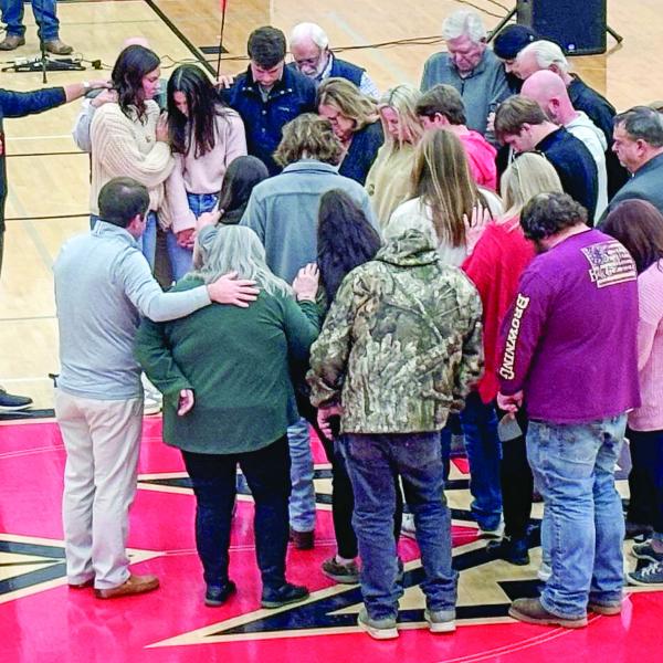 The families of Bennett Rabern, Avett Jackson, and Bryson Hammond are prayed over at a community vigil held Sunday at Morgan County High School. HANNAH BARRON/Staff