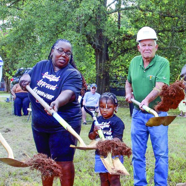 Helping to toss the ceremonial first shovelfuls of dirt alongside Standish Avenue was Putnam County Commission Chairman Bill Sharp (left), beside soon-to-be homeowner Tawana Ellison and her four-year-old daughter Gracelyn. (IAN TOCHER/Staff)