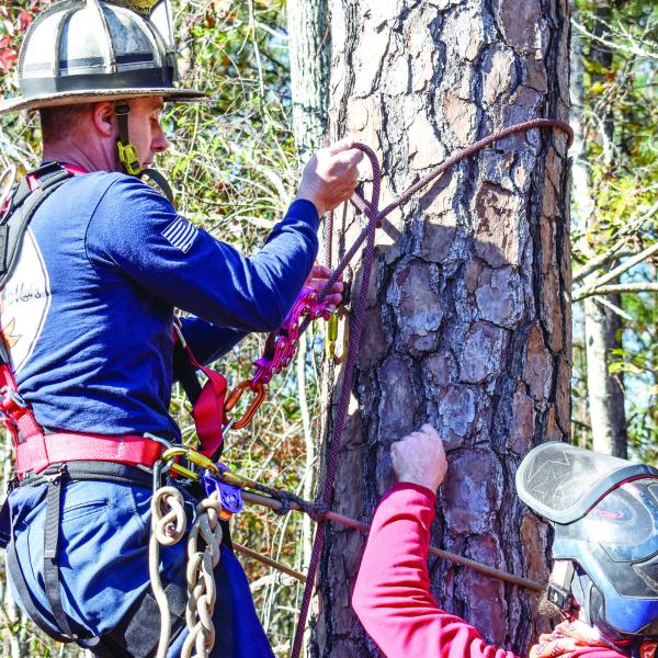 Fire Chief Rodney Wiggins learns aerial rescue techniques from an arborist at Arbor Equity Dec. 4. HANNAH BARRON/Staff
