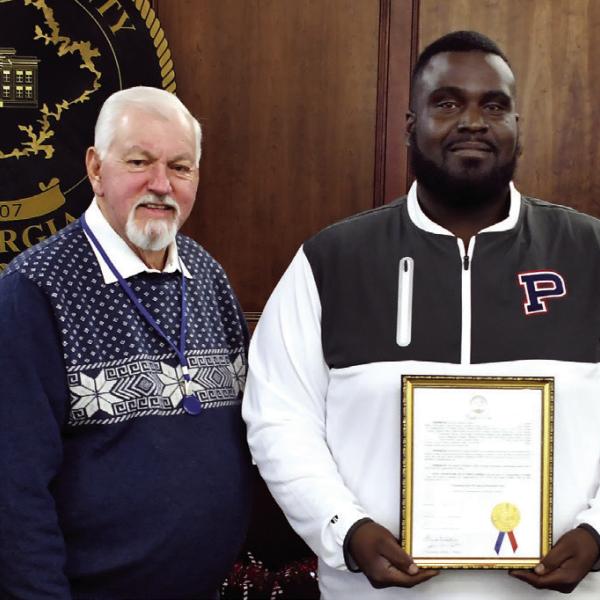 On behalf of his fellow coaches and a roster 39 players, Alexander Banks, head coach of the 2025 Putnam County Middle School War Eagles football team, accepted a framed proclamation last Tuesday night recognizing the team’s 2025 state championship from (l-r) Commissioner Jeff Wooten, Chairman Bill Sharp, and Commissioner Tom McElhenney. IAN TOCHER/Staff