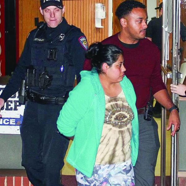 Reyna Lopez, front center, is escorted by Eatonton Police Department officers Chris Detweiler (left) and investigator Hargrove Jones, who are taking Lopez to jail at Putnam County Sheriff’s Office. CONTRIBUTED/EPD