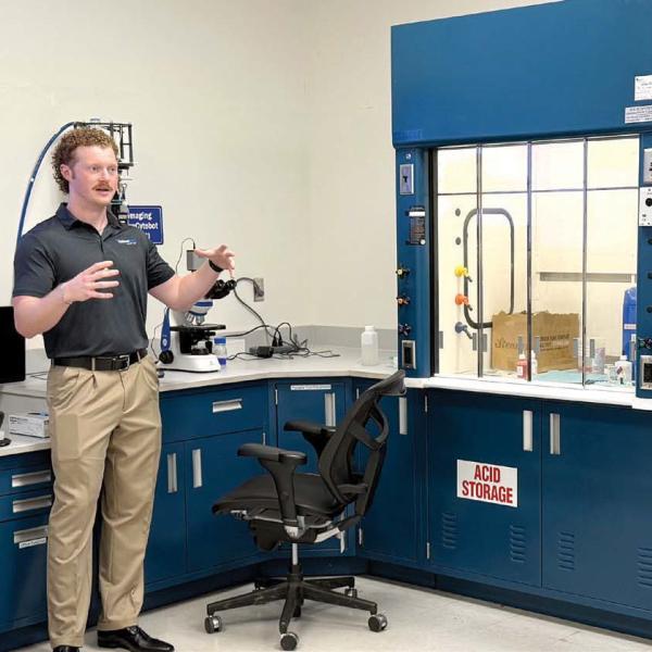 Piedmont Water lab supervisor Kyle Craig (second from left) speaks to visitors about his work in the site’s microbiology lab. CONTRIBUTED