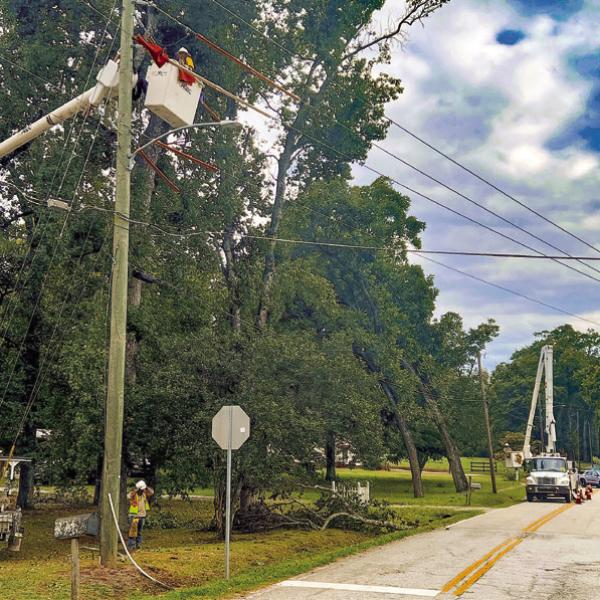 Crews work on downed limbs and power lines at the intersection of North Maple Avenue and Madison Road at the north end of Eatonton. IAN TOCHER/Staff