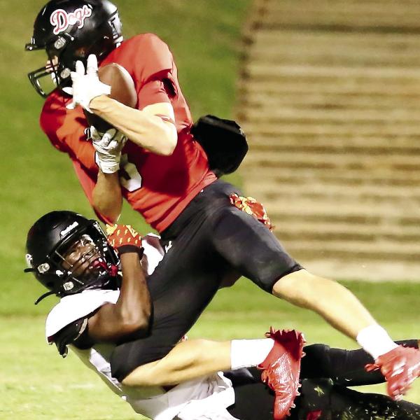 Former Morgan County wide receiver Dallas Dickerson tries to secure a catch as a defender brings him down to the ground during a game in 2023. JIM TURNER/Contributed