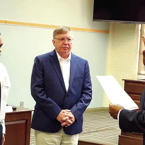 Madison’s new police chief John McIlvaine (left) is sworn in by Mayor Fred Perriman while City Manager John Klimm looks on. T. MICHAEL STONE/Staff