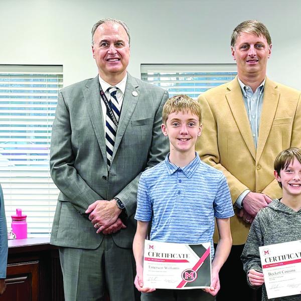 (L-R in front of board members): District spelling bee champion Emerson Williams and runner-up Beckett Cousins are recognized by the Board of Education. HANNAH BARRON/Staff