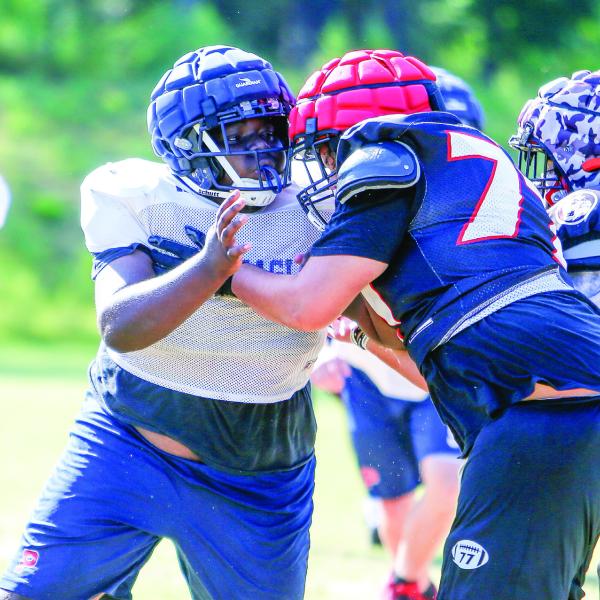 A Putnam County defensive lineman (72) goes up against an offensive lineman from Winder-Barrow during a padded camp held in Eatonton on July 17. LANCE McCURLEY/Staff
