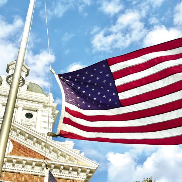 The flag flies at half-staff outside the Morgan County Courthouse Sunday, in memory of Greene County Fire Rescue Battalion Chief Chris Eddy. (HANNAH BARRON/Staff)
