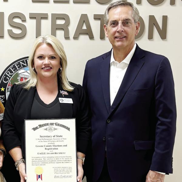 Elections director Rebecca Anglin receives the award from Georgia Secretary of State Brad Raffensperger. CONTRIBUTED