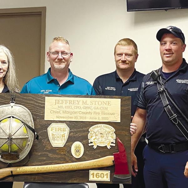 A custom-made commemorative plaque was presented to the retiring chief as part of the retirement reception. Pictured from left to right are: Battalion Chief Dusty Powell, Administrative Assistant Cindy Williams, Chief Jeff Stone, Battalion Chief Josh Tinseth and firefighters Jake Mason and Chris Tuck. T. MICHAEL STONE/Staff