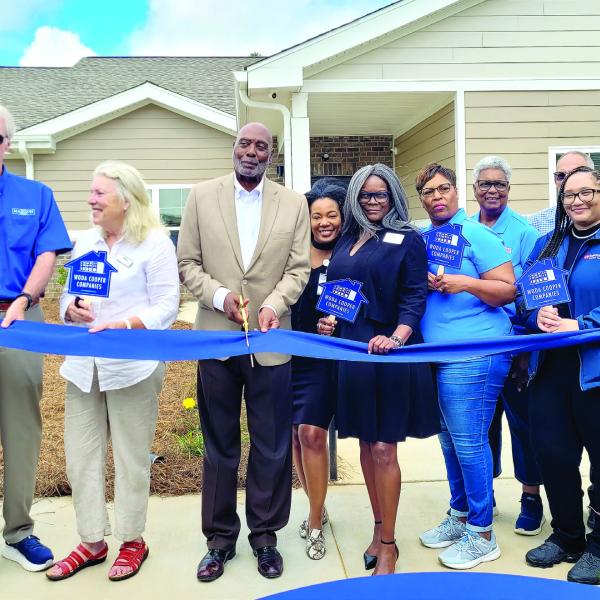 Madison Mayor Fred Perriman (center) cuts the ribbon at the Carmichael Commons grand opening, alongside city council members and representatives of several contributing companies. SKYLA MORRIS/Staff