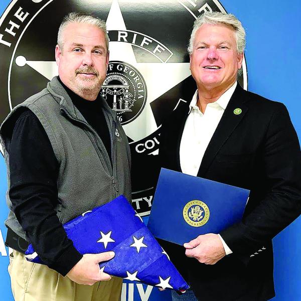 U.S. Rep. Mike Collins presents Sheriff Robert Markley (left) with a flag that was flown over the U.S. Capitol in honor of his time serving Morgan County. CONTRIBUTED
