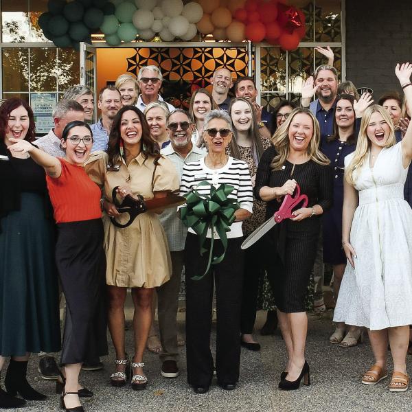 With plenty of support from friends and colleagues, Jackie Greer (center with black scissors) made the official ribbon cut for her new space for Greer Force Marketing at 1001 Village Park Dr., Unit 108, in Greensboro. IAN TOCHER/Staff