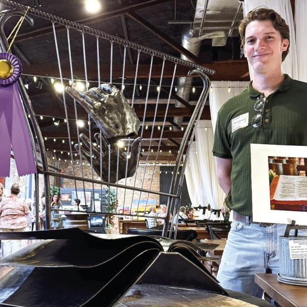 Inspired by an open-book photo of a Bible (right), Brian Danson created an allmetal sculpture featuring a pair of disembodied hands playing a harp that drew enough votes for him as the event’s Peoples’ Choice-winning artist. CONTRIBUTED
