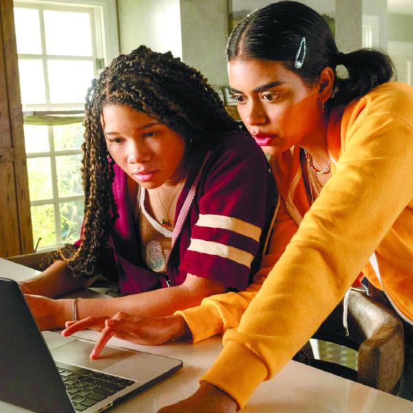 Jude, played by Storm Reid, (left) looks at Kevin’s social media with her best friend Veena, played by Megan Suri. TEMMA HANKIN/Sony Pictures