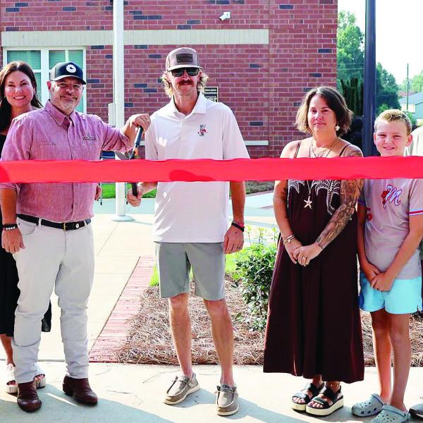 The families of Bennett Rabern and Avett Jackson did the honors of cutting the ribbon for the Rabern-Jackson Memorial Garden July 30 at Morgan County Middle School. SKYLA MORRIS/Staff
