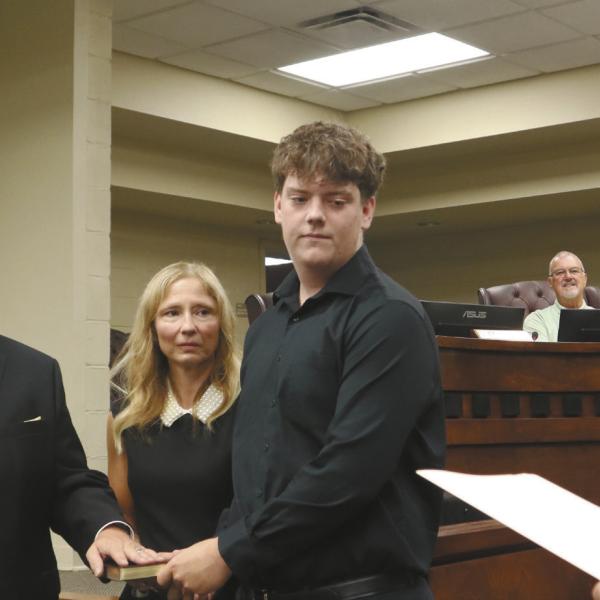 Dr. Arryn Schmuhl stands alongside his wife and son while taking the oath of office as the GCSS superintendent. COURTESY OF GREENE COUNTY SCHOOLS