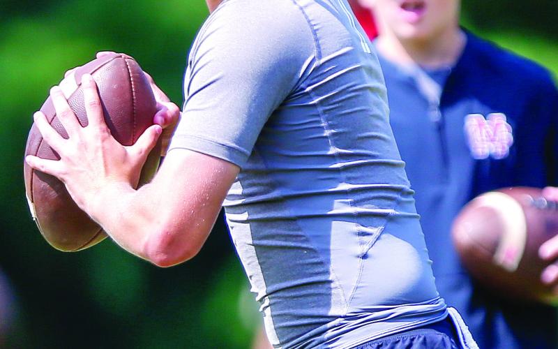 Junior quarterback Gunner Braswell prepares to throw a pass downfield during a 7-on-7 competition at UGA in June. LANCE McCURLEY/Staff