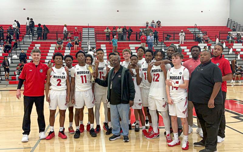 Morgan County boys basketball players and staff members pose for a photo after defeating the Hurricanes. CONTRIBUTED