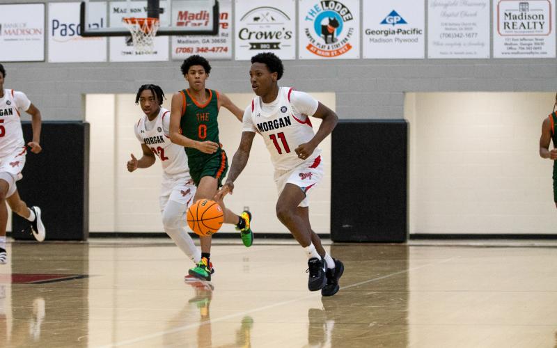 Morgan County senior guard Zeki Locus (11) pushes the ball up the floor in transition. He scored 23 points and grabbed 24 rebounds in the region championship win over Rutland. SKYLA MORRIS/Staff