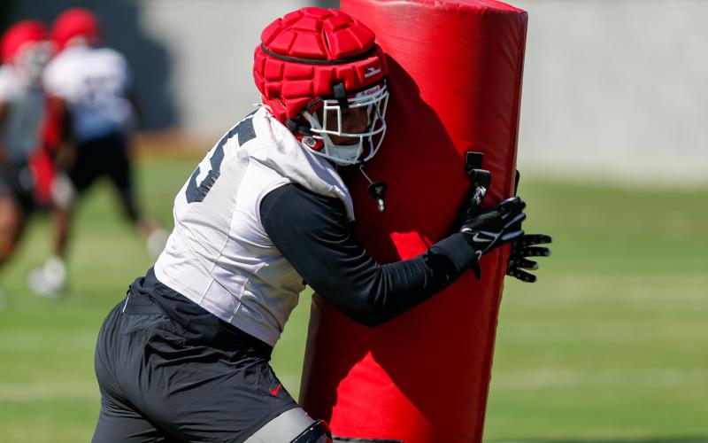 Georgia defensive lineman Nnamdi Ogboko hits a practice dummy at full speed during a drill at practice on March 19. LANCE MCCURLEY/Staff