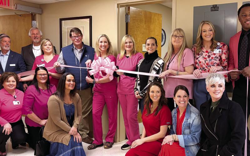 Putnam General Hospital staff and local officials, including Putnam County Clerk of Courts Trevor Addison (far left) and Eatonton-Putnam Chamber of Commerce CEO Robbie King, with Putnam General CEO Alan Horton (second and third from left, respectively), join office and medical staff members in celebrating the installation of a high-tech mammography machine at the Eatonton-based medical center. SKYLA MORRIS/Staff