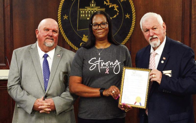 Prior to the start of the Oct. 4 Putnam County Commission meeting, Commission Chairman Bill Sharp (holding frame) invited County Human Resources Director Cynthia Miller to join him and (l-r) Commissioners Daniel Brown, Jeff Wooten, and Stephen Hersey in a proclamation recognizing the month of October as Breast Cancer Awareness Month. (IAN TOCHER/Staff)