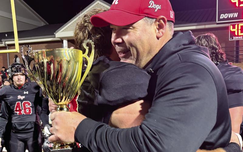 Brody Jenkins hugs his father, Clint Jenkins, after the Dogs defeated Callaway to win the Region 2-AA championship last season. HANNAH KNIGHT/Contributed