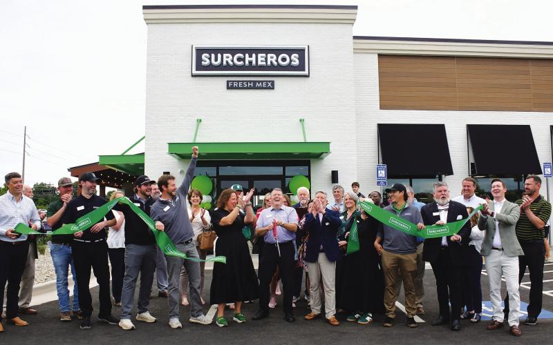 Kyle Cullars (center, holding scissors) completes the ribbon cutting for Surcheros, a new Tex-Mex restaurant alongside Hwy. 44, near the Thunder Pointe neighborhood on Lake Oconee. IAN TOCHER/Staff