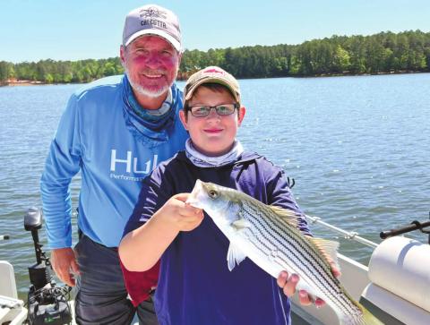 Kevin Harris and Beau with a striper. CONTRIBUTED