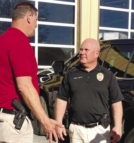 Locust Grove Police Chief Derrick Austin, right, talks with LGPD Lt. Brandon Morris outside of the Putnam County Coroner’s Office Sunday afternoon. LYNN HOBBS/ Staff