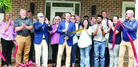 Piedmont Water owner Adam Shaifer (center) cuts the ribbon for the company’s Customer Care and Learning Center April 15 as employees, the Eatonton-Putnam Chamber of Commerce, Greene County Chamber of Commerce, and community members celebrate. HANNAH BARRON/Staff