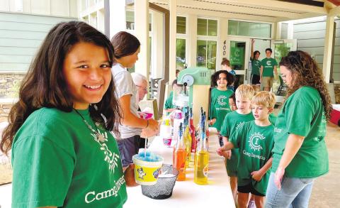 Staff members and volunteers hand out SnoBiz Shave Ice to campers during a break at Lake Oconee Academy’s Camp Invention. CONTRIBUTED