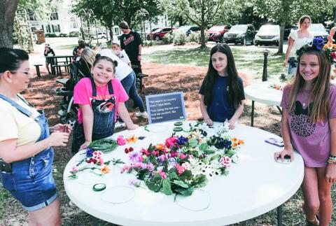 Children enjoy making flower crowns at the May Day event. CONTRIBUTED
