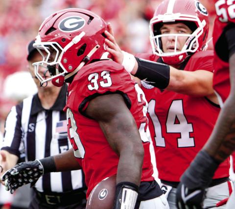 Georgia running back Chauncey Bowens (33) celebrates with teammates after scoring a touchdown against Austin Peay on Saturday. LANCE McCURLEY/Staff