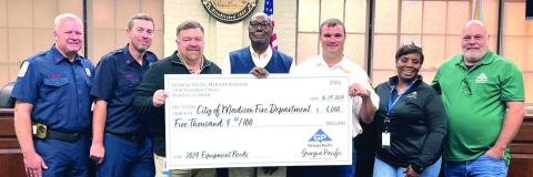 (L-R) Kevin Whitley, Josey Cameron, Georgia-Pacific plant manager Wesley Stone, Mayor Fred Perriman, Assistant Fire Chief Daniel Pennington, Tracy Brewer, and Georgia-Pacific assistant plant manager Scott Lamar at the check presentation for the Madison Fire Department. CONTRIBUTED