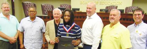 Greene County High School student Aiden Turner (center) was recognized at the May 19 Board of Education meeting for being selected for the Georgia Governor’s Honors Program. (from left) BOE members Joe Bashore and Clarence Hunt, Chairman Mike Lynch, Turner, School Superintendent Chris Houston and BOE members Steve Kilgore and Perry Lee. MARK ENGEL/ S t a ff