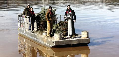 Georgia Power, the Georgia Wildlife Resource Department, and the Lake Oconee Bass Masters Fishing Club help Rotary members sink Christmas trees repurposed as fish habitats. CONTRIBUTED