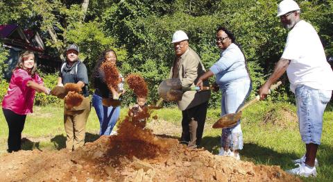 Flanked by Putnam Habitat for Humanity board member Jack McDonald and her children, Barbara Monday (second from left) was all smiles as she participated Monday in the official groundbreaking ceremony for her new home to be completed by early next spring on South Madison Street in Eatonton. IAN TOCHER/Staff