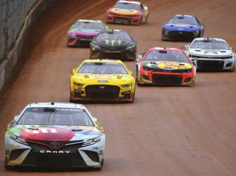 Winner Kyle Busch, driver of the #18 Mars Crunchy Cookie Toyota, drives during the Cup Series Food City Dirt Race at Bristol Motor Speedway Sunday night. (Logan Riely/Getty Images)