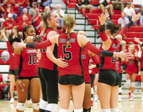 The Spike Dogs celebrate as a team following Tuesday night’s win over East Jackson. LANCE McCURLEY/Staff