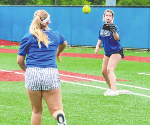 From the mound to first base, Lake Oconee Academy softball players worked on throwing around the infield last week during a practice. LANCE McCURLEY/Staff